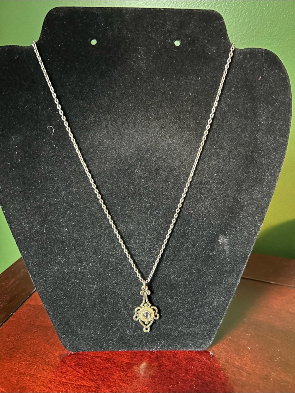 Delicate Silver-Tone Pendant Necklace with Antique Motif and Bullet Center